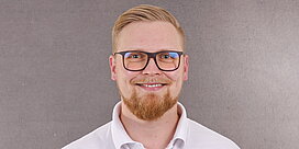 Portrait des Servicemitarbeiters Markus Noack vor grauem Hintergrund.