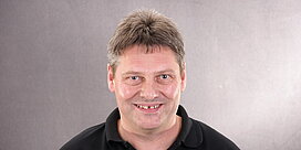 Portrait des Teile- und Zubehörberaters Walter Krauß aus Höchst vor grauem Hintergrund.
