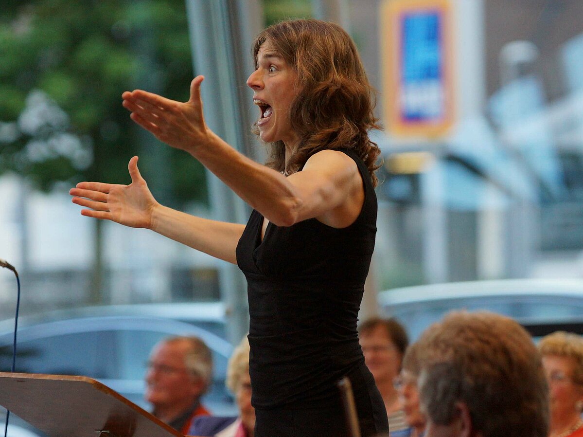Iris Thierolf beim Singen und Dirigieren des Gospelkonzerts 2013 im Audi Hangar in Michelstadt.